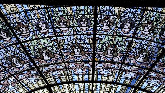 Blue stained-glass panels with a row of women's faces