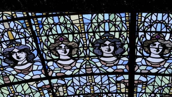 Four stained-glass faces in blue and green