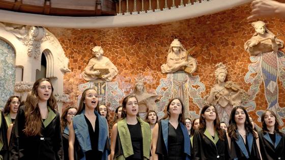 A young women's choir singing in front of the mosaic muses