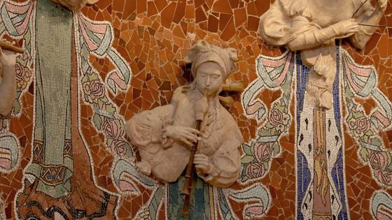 A muse playing a flute on the orange mosaic